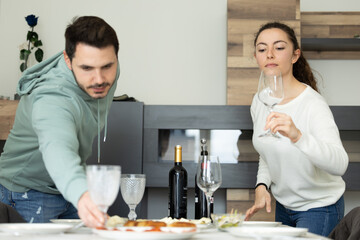 man and woman setting the table at home