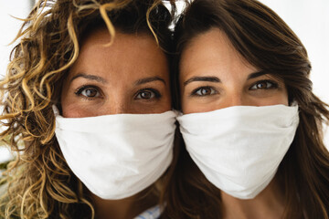 Photo of two women looking straight at camera with face masks during quarantine due to Covid-19 or...