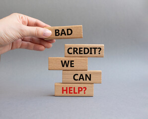 Bad credit We can Help symbol. Wooden blocks with words Bad credit We can Help. Beautiful grey background. Businessman hand. Business and Bad credit We can Help concept. Copy space.