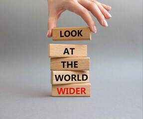 Look at the world wider symbol. Wooden blocks with words Look at the world wider. Beautiful grey...