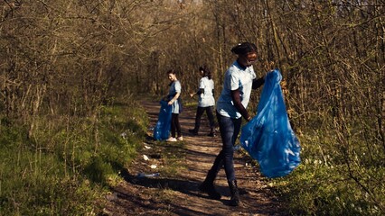 Group of diverse activists picking up the trash and plastic waste, collecting and recycling rubbish...