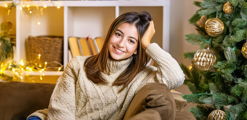Young woman smiling in cozy room with Christmas decorations