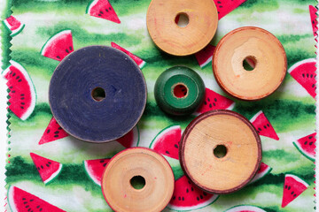 wooden roundels (vintage stacking toy pieces) on seasonal fabric square featuring watermelon print