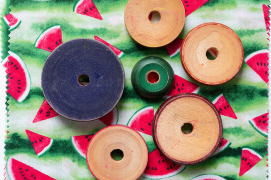 wooden roundels (vintage stacking toy pieces) on seasonal fabric square featuring watermelon print