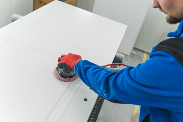 Carpenter using sander while working on a piece of wood. High quality photo