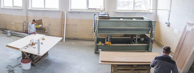 wide angle view of carpenters working in the factory, wood industry. High quality photo