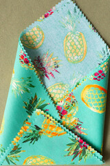 folded seasonal fabric squares with zigzag edges featuring pineapple prints on paper