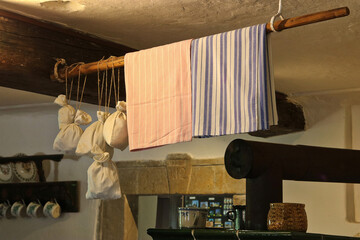 A perch above the stove in an old cottage, on which canvas bags with dried herbs and tea towels are hung
