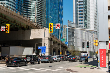 Obraz premium eastbound traffic on Harbour Street with signage and cement pylons of Gardiner Expressway in downtown Toronto, Canada