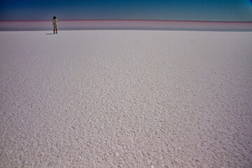 Person standing  at water edge on Lake Eyre salt plain