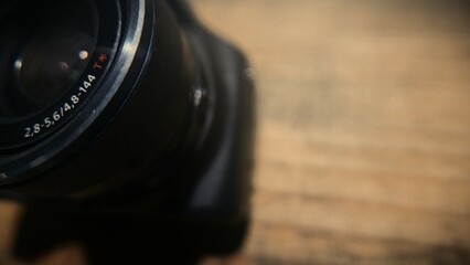 An overhead shot of a digital camera on the table: a close-up of a camera lens. A professional...