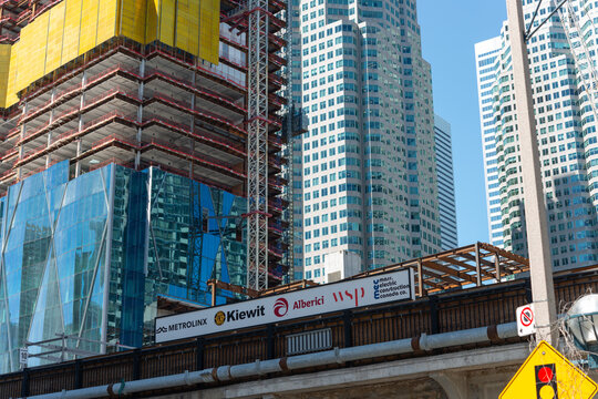financial corporate offices at CIBC Square (under construction at left) and development firms sign on bridge side: Metrolinx, Kiewit, Alberici, wsp, mass electric company canada)