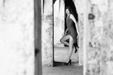 The beautiful girl in an evening dress against an old wall