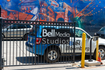 Obraz premium sign on the security gates outside Bell Media Studio (with BNN Bloomberg vehicle) in the parking lot at 299 Queen Street West in Toronto, ON