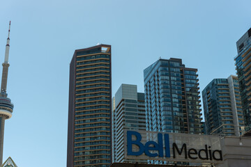 Obraz premium Bell Media Headquarters sign (299 Queen Street West) in the shade with buildings behind on a blue spring sky in Toronto, Canada 