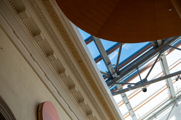 Obraz premium glancing up at the ceiling and decorative moulding with sky light inside Walker Court (with part of winding wood staircase) at the Art Gallery of Ontario in Toronto