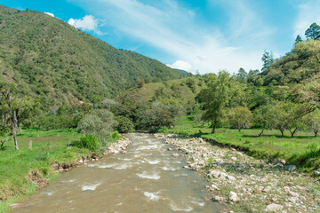 mountainous landscape with a river that runs through the green valley