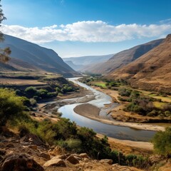 Scenic mountain valley landscape with river and cloudy sky