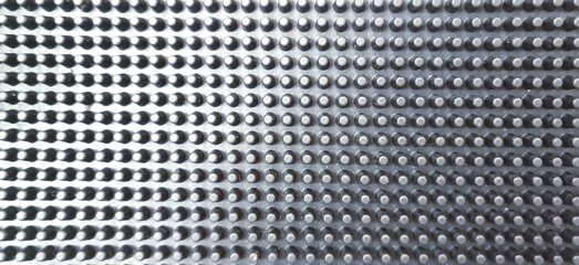 Abstract metal background with perforated holes. Close-up.