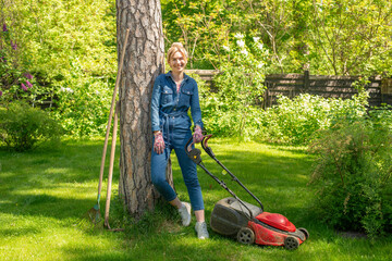 woman on the grass with a lawnmower