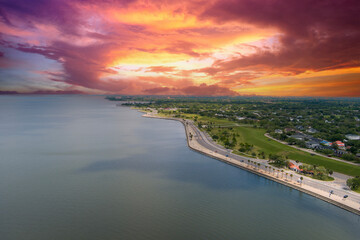 aerial shot along the coast of Lake Pontchartrain with homes, lush green trees, plants and grass,...