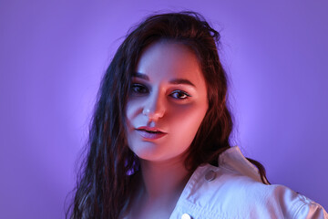 Portrait of beautiful young woman on color background with neon lights