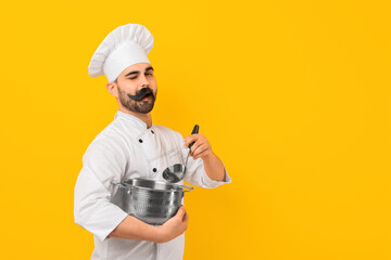 Professional chef with funny artificial moustache holding cooking pot and ladle on yellow...