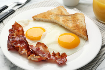 Delicious breakfast with sunny side up eggs on white marble table, closeup