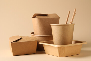 Eco friendly food packaging. Paper containers and tableware on beige background
