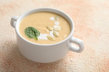Healthy cream soup high in vegetable fats on color textured table, closeup