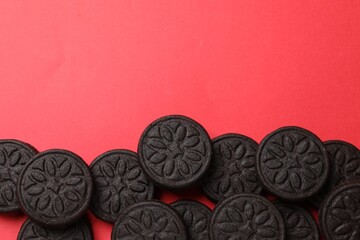 Tasty sweet sandwich cookies on red background, flat lay. Space for text