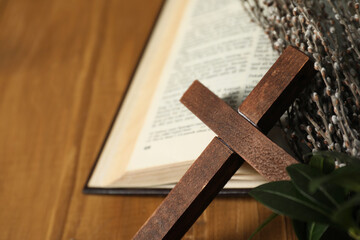 Cross, Bible and willow branches on table, closeup. Space for text