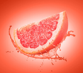 Fresh grapefruit with splashing juice on coral gradient background