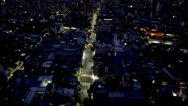 Ciudad a la noche, transito en la calle, vista desde dron.