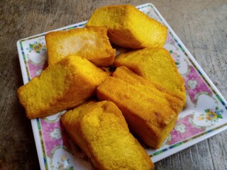 Tahu kediri. Yellow tofu or what is known as tofu kediri which has been fried and placed in a container. Yellow tofu is a typical food from the city of Kediri, Indonesia.