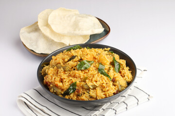 Sambar Rice - Tasty and popular south indian recipe served in a ceramic bowl with appalam or papad