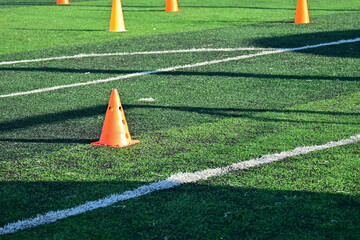 artificial green grass soccer field with orange training cones