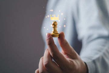 Businessman hand holding pawn chess for business strategy and leadership assignment concept.	
