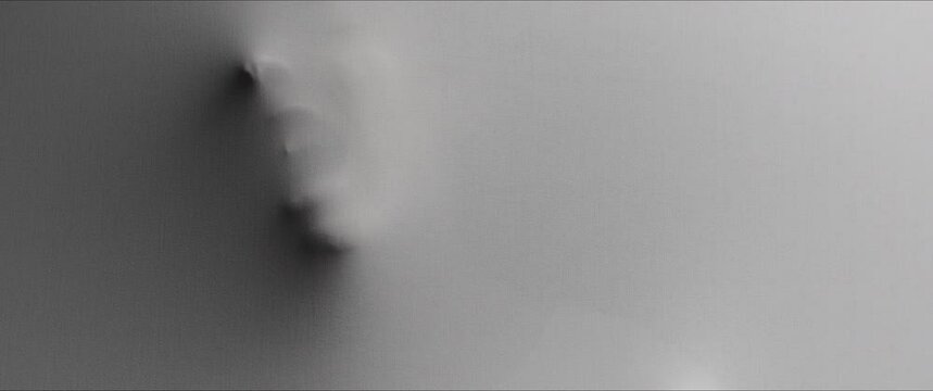 A scary woman's face extrudes from the wall 