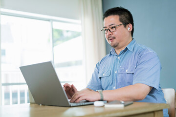 自宅でリモートワークをする大柄な日本人男性