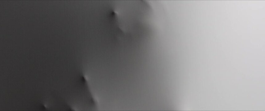 A  skinny woman's face and hands appear from the wall surface 