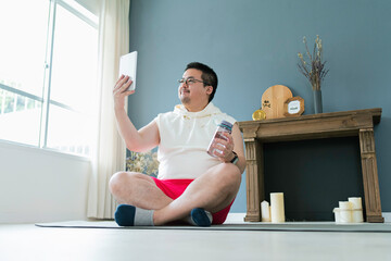 タブレットで動画を見ながらトレーニングをする大柄な日本人男性
