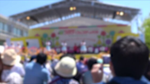 ぼかし背景素材: 野外ライブ会場に集まった大勢の観客たちの後ろ姿