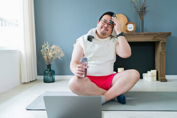 PCで動画を見ながらトレーニングをする大柄な日本人男性