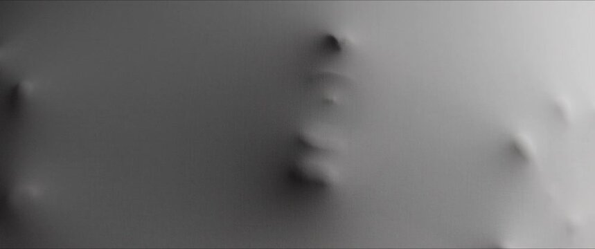 A skinny woman's face with teeth extrudes from the wall surface
