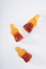 Creative atmosphere of sweet soft soda gummies on white background