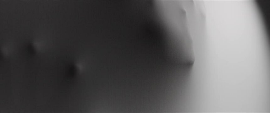 Woman's hands and face extrude from the wall surface
