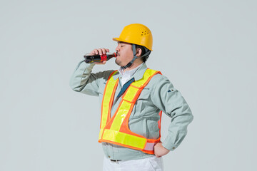 コーラを飲む作業服の男性