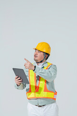 タブレット端末を見ながら指示を出す作業服の男性