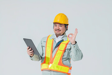 タブレット端末を持ってOKサインをする作業服の男性